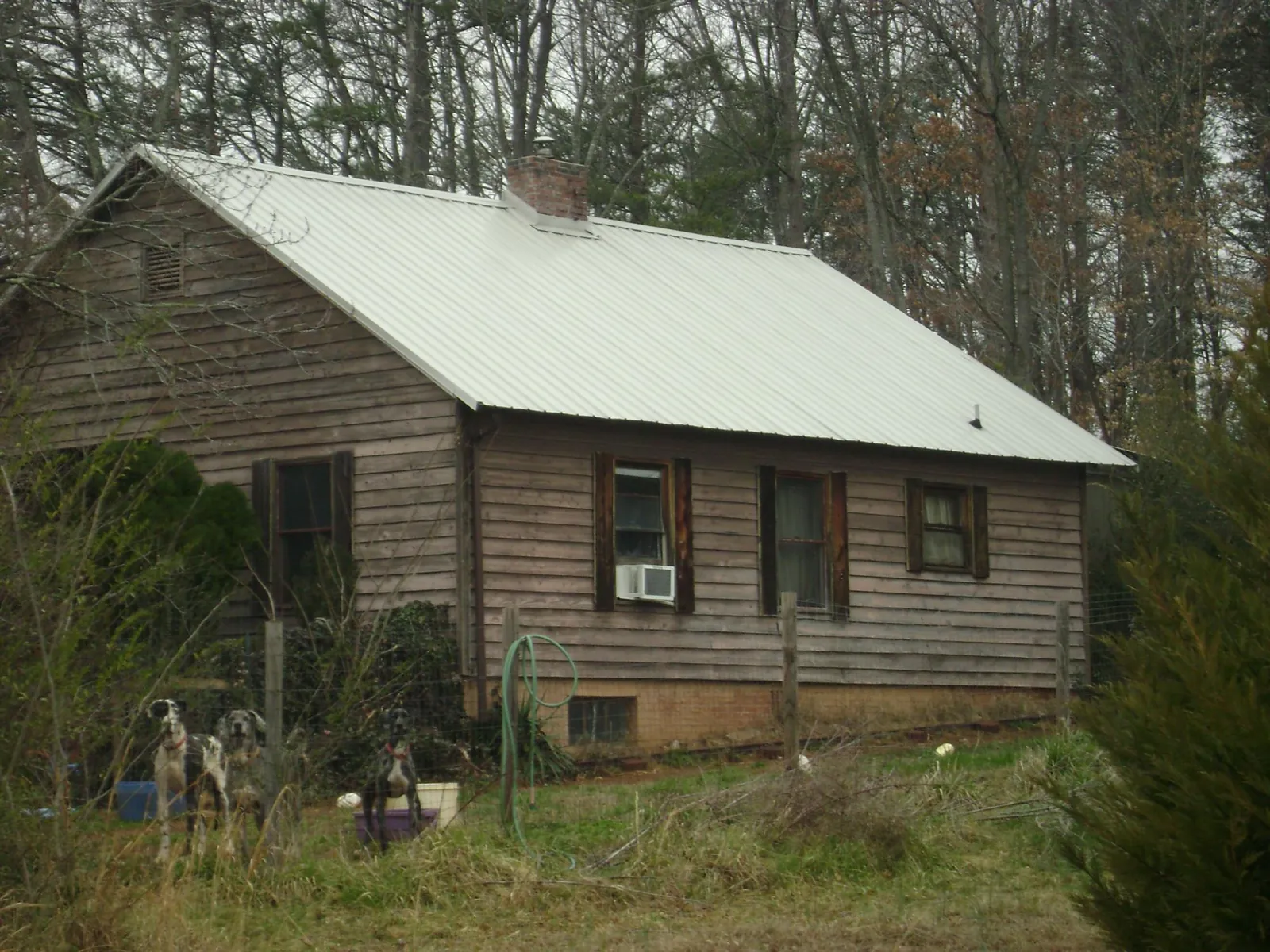White metal roof on an old wood sided farmhouse, from a Metal Roof Installation job in Hamlin